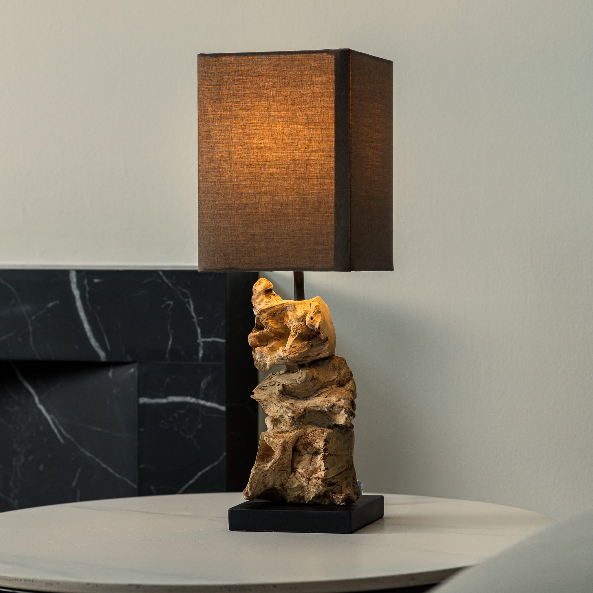 Eloria table lamp with stacked driftwood base and dark linen shade on bedside table, handcrafted natural lighting by Willow Tree Decor